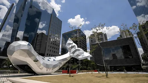 Prédios espelhados da região da Faria Lima, em São Paulo, com uma escultura de baleia na praça.