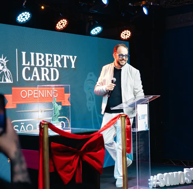 Wesley Ribeiro ao microfone no palco da inauguração da Liberty Card em São Paulo.